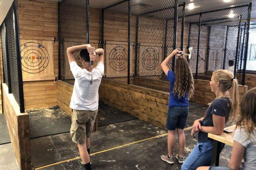 two people throwing axes at a target